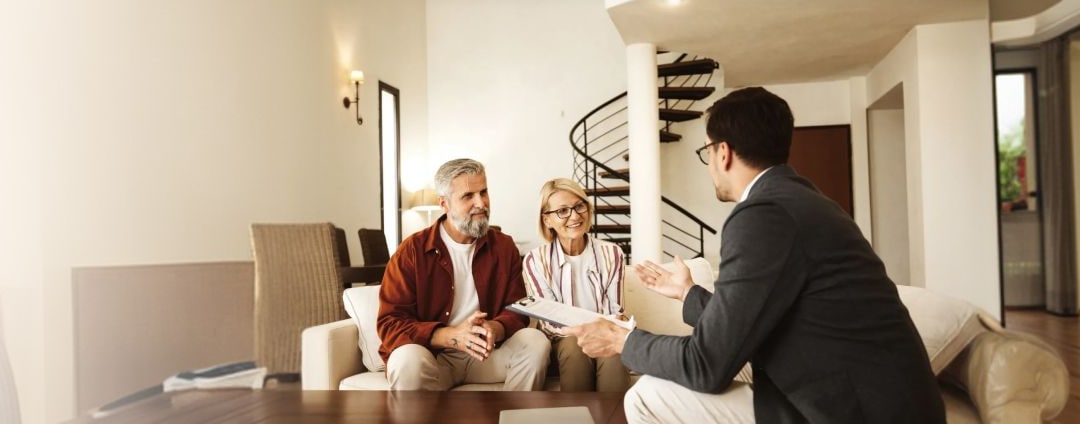Couple sitting on sofa talking with gentleman about estate plan