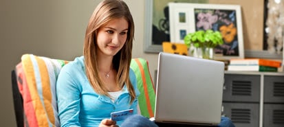 female-indoors-on-laptop-with-debit-card
