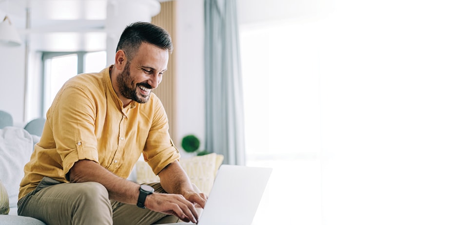 large_marquee_desktop_man_sitting_on_couch_with_laptop_970x462