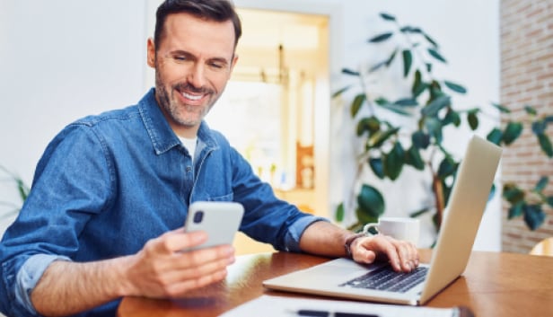 Man_with_smartphone_laptop_616x353