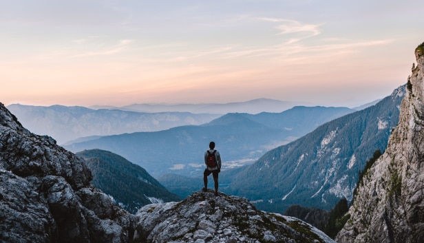 Person on mountaintop to represent setting and achieving goals with LifeSync