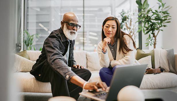 Lifestyle. Two person sitting together looking at laptop.