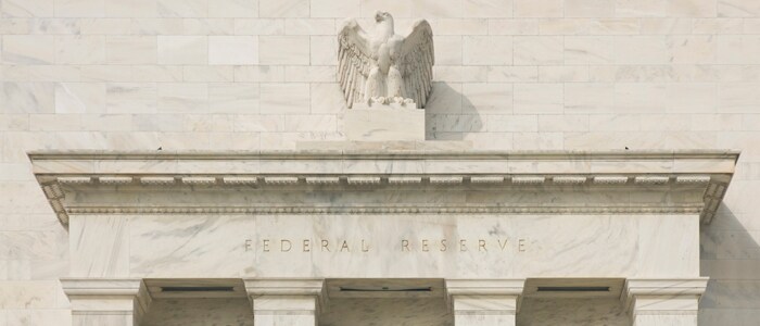 federal reserve building with eagle in the top center of the pillar